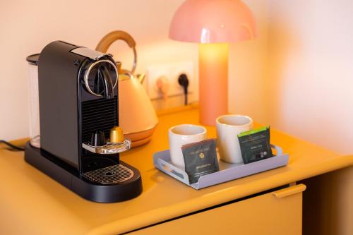 une cafetière et deux tasses sur une table dans l'établissement Nice Pam Hotel, à Nice