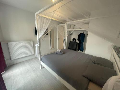 - une chambre avec un lit et un cadre de lit blanc dans l'établissement Résidence Relaxante Jacuzzi - 041, à Rouen