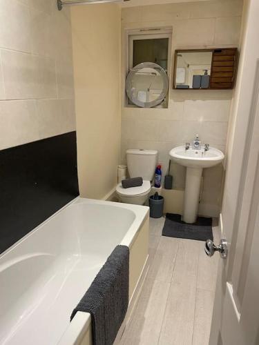 a bathroom with a tub and a toilet and a sink at Flat 3 Meadow View Cozy Getaway in Hurst
