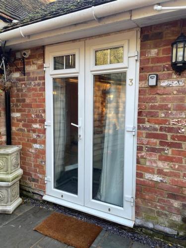 a white door on the side of a brick house at Flat 3 Meadow View Cozy Getaway in Hurst
