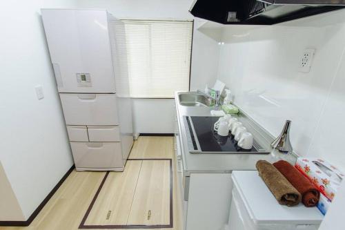 a white kitchen with a stove and a refrigerator at QiQi House Tokyo Hirai Villa 2Bath3WCs 4min Station 24min to Akihabara in Tokyo