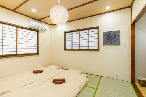 two beds in a room with two windows at QiQi House Tokyo Hirai Villa 2Bath3WCs 4min Station 24min to Akihabara in Tokyo