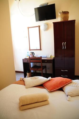 a bedroom with a bed with a desk and a mirror at Palmeiras Guest House Maputo in Maputo