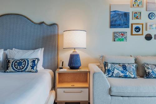 a bedroom with a bed and a chair and a lamp at The Seagate in Delray Beach
