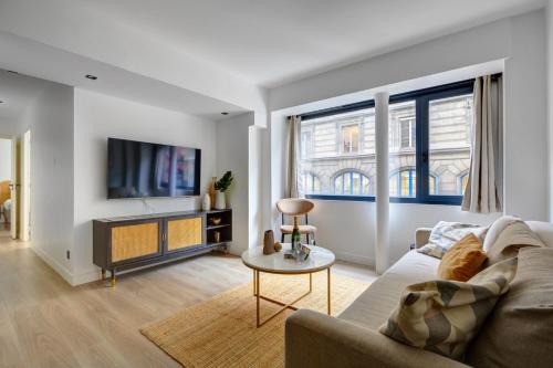a living room with a couch and a tv at Bluestay 123 - Superb apartment in Paris in Paris