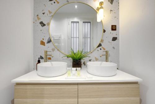 une salle de bain avec deux lavabos et un miroir dans l'établissement Bluestay 123 - Superb apartment in Paris, à Paris