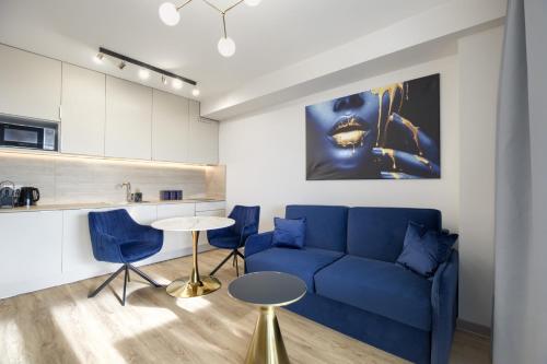 a living room with a blue couch and a table at AboutArtApartments - Otyńska 4 in Wrocław