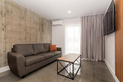 a living room with a couch and a table at Le Boréal Abitibi Hôtel in Val-dʼOr