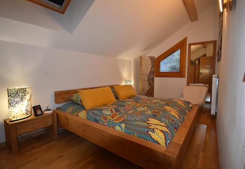 une chambre avec un lit et une table avec une lampe dans l'établissement VAUJANYLOCATIONS - EdelweissD07, à Vaujany