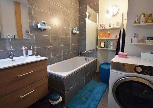 La salle de bains est pourvue d'une baignoire et d'un lave-linge. dans l'établissement VAUJANYLOCATIONS - EdelweissD07, à Vaujany