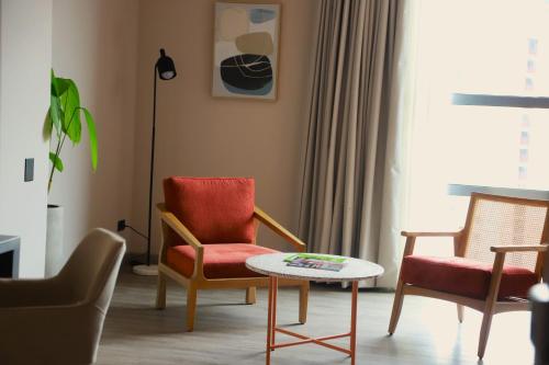 a living room with two chairs and a table at Tequendama Hotel Medellín - Estadio in Medellín