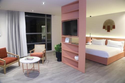 a hotel room with a bed and a tv at Tequendama Hotel Medellín - Estadio in Medellín