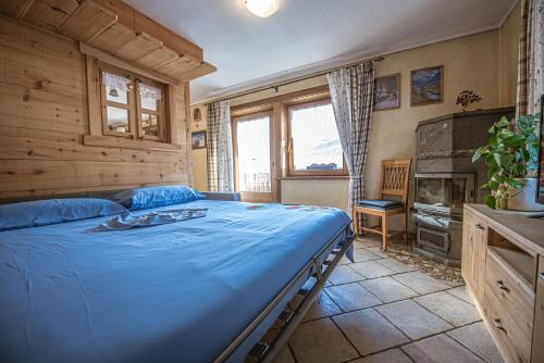 sypialnia z niebieskim łóżkiem i kominkiem w obiekcie Apartments & Rooms MyHolidayLivigno w Livigno