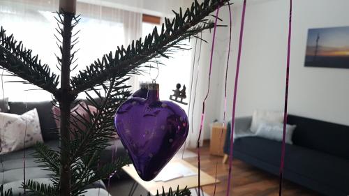 a purple heart ornament on a christmas tree in a living room at Ferienhus Klus 415 in Mellau