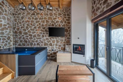 a living room with a fireplace and a stone wall at Πηγή Τραγανιστή in Kato Trikala Korinthias