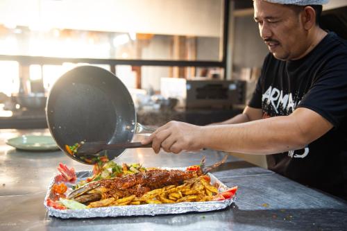 a man is preparing food in a kitchen at The Rose Goa Beach Resort in Agonda