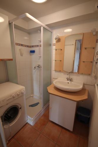 une salle de bain avec un lavabo et une machine à laver dans l'établissement Belle villa 4 -5 couchages 2 chambres terrasse piscine commune parking dans résidence sécurisée 300m de la mer LRMA82, à Portiragnes
