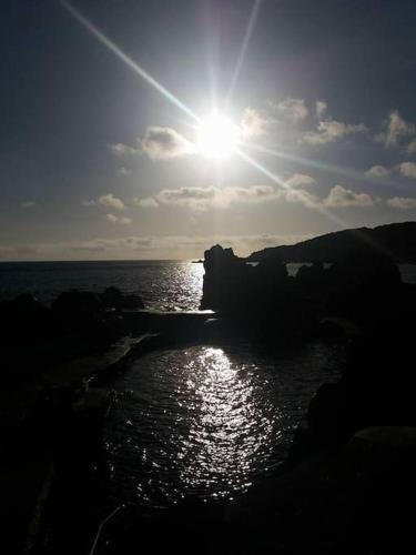 a sun setting over the water with the sun shining at Sky Apartamentos Vista Do Atlântico in Capelo