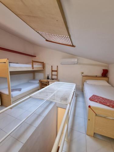 ポルト・アッズッロにあるLa casina di Adinaの二段ベッド2台とテーブルのある部屋