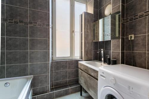 une salle de bain avec un lavabo et une machine à laver dans l'établissement Appartement idéal pour visiter Strasbourg, à Strasbourg