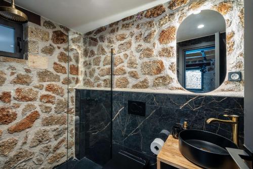 a stone bathroom with a sink and a mirror at Πηγή Τραγανιστή in Kato Trikala Korinthias