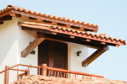 a balcony of a house with a roof at Refugio de piedra - Troncones in Troncones