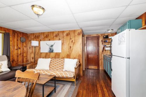 a living room with a couch and a refrigerator at Chippewa Bluffs Resort Combined 3BR 3BA Cabins in Barryton