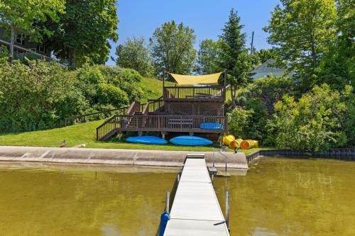 a dock in the middle of a body of water at Chippewa Bluffs Resort Combined 3BR 3BA Cabins in Barryton