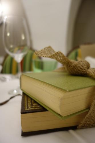 a stack of books sitting on a table with a wine glass at Villa Bucher - Metnitztalerhof in Friesach