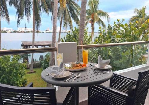 a table with a bowl of food on a balcony at SINA SUITES CANCUN - Adults Only in Cancún