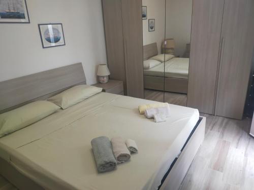 a bedroom with a white bed with towels on it at La Dependance in Centro in Follonica