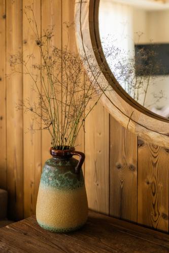 a vase sitting on a table next to a mirror at The Pines Bucegi Lodge in Bran