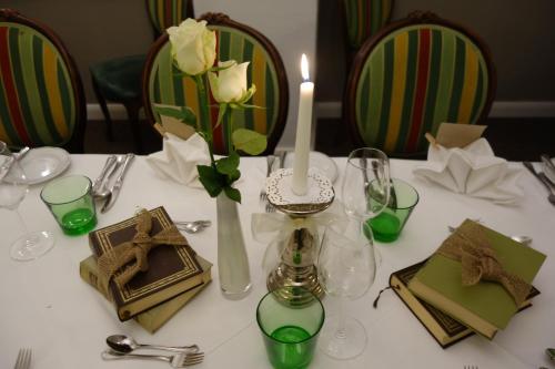 a white table with a candle and a vase with flowers at Villa Bucher - Metnitztalerhof in Friesach