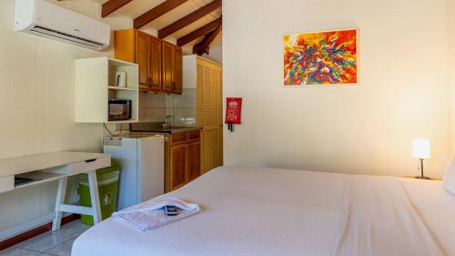 a small kitchen with a white bed in a room at Talk of the Town Inn & Suites - St Eustatius in Oranjestad
