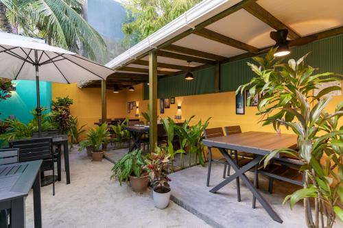 an outdoor patio with tables and chairs and plants at Ukulhas Sands in Ukulhas