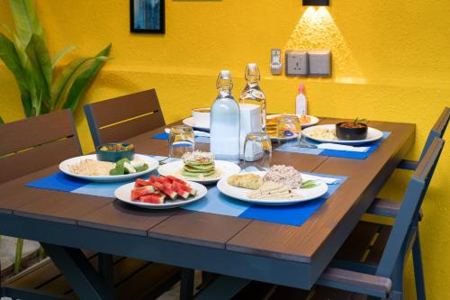a wooden table with plates of food on it at Ukulhas Sands in Ukulhas
