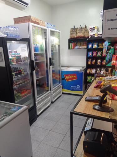 a store with two refrigerators and a phone on a table at flat no centro da Cidade in Campos dos Goytacazes