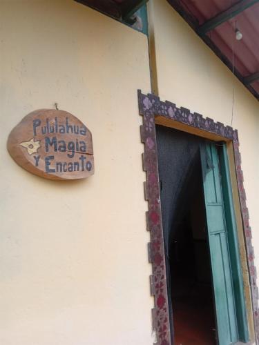 a sign on the side of a building with a doorway at Pululahua Magia y Encanto in Quito