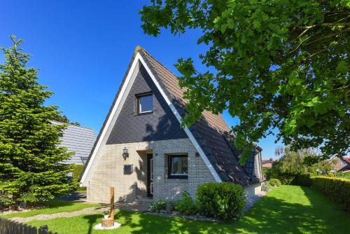 a small white church with a gambrel roof at Ferienhaus Boje 13 in Neuharlingersiel