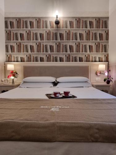 a bedroom with a bed with a book shelf with books at Hotel Charly in Milan