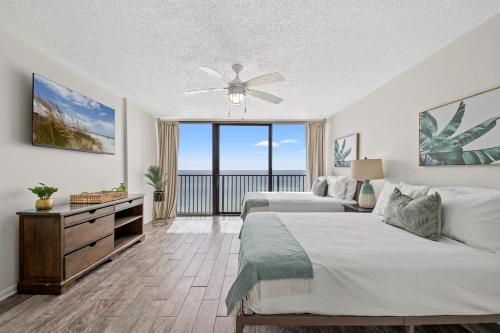 a bedroom with two beds and a ceiling fan at Sandpiper Beacon Beach Resort in Panama City Beach