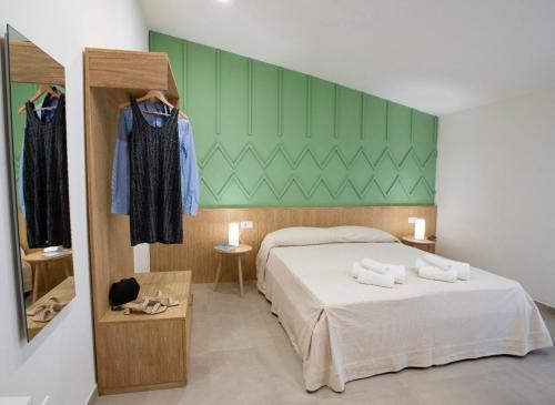 a bedroom with a bed and a green wall at Tarsis Guest House in Baunei