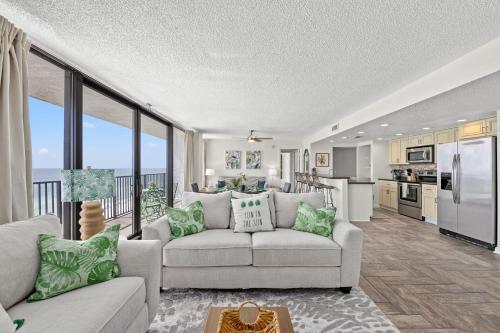 a living room with a couch and a kitchen at Sandpiper Beacon Beach Resort in Panama City Beach