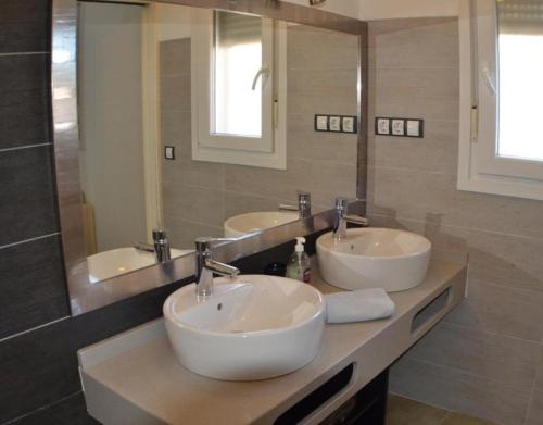 Un baño con dos lavabos y un espejo grande. en Casa Daniela 2, en El Pozo de los Frailes