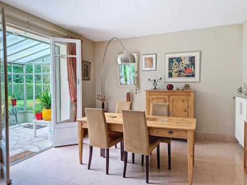 une salle à manger avec une table et des chaises en bois dans l'établissement Cour Tholmer, à Touques