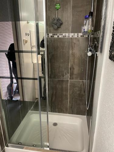 une douche avec une porte vitrée dans une salle de bain dans l'établissement Résidence Clos de Tamaris, à Marseillan