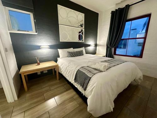 a bedroom with a large bed and a table at 31 Akrotiri, Santorini, Ballito in Ballito