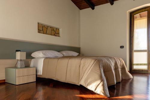 a bedroom with a bed and a lamp on a wooden floor at Villa Carlotta in Nuxis