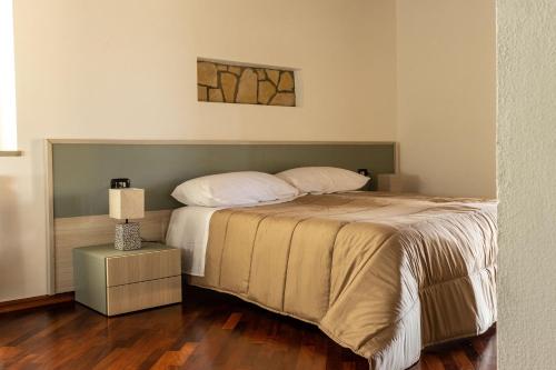 a bedroom with a large bed with a night stand at Villa Carlotta in Nuxis