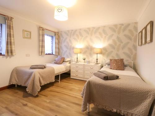 a bedroom with two beds and a dresser in it at Kingfisher in Wattisfield